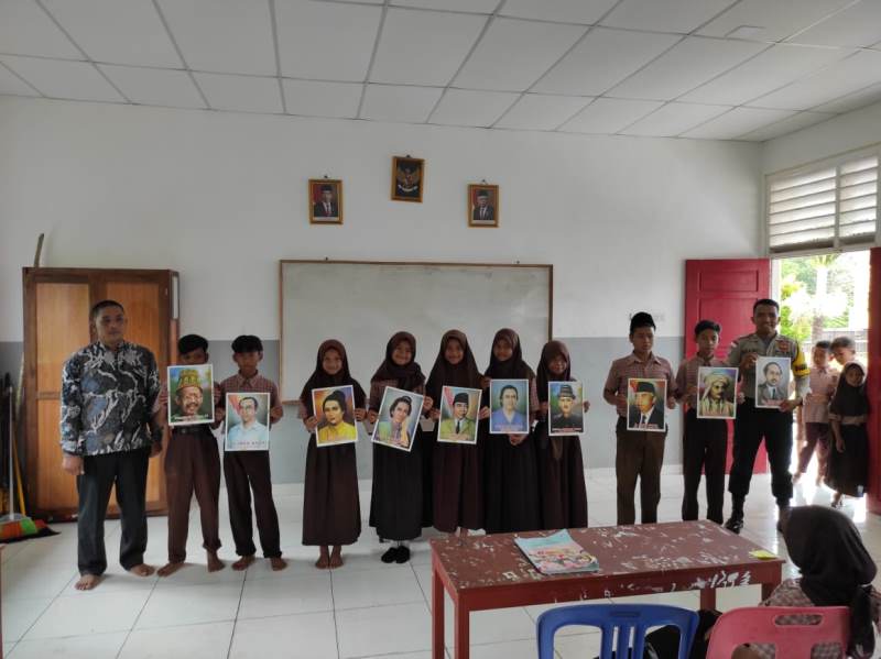 Peringati Hari Pahlawan, Bhabinkamtibmas di Rangsang Ini Bagikan Poster kepada Murid SD